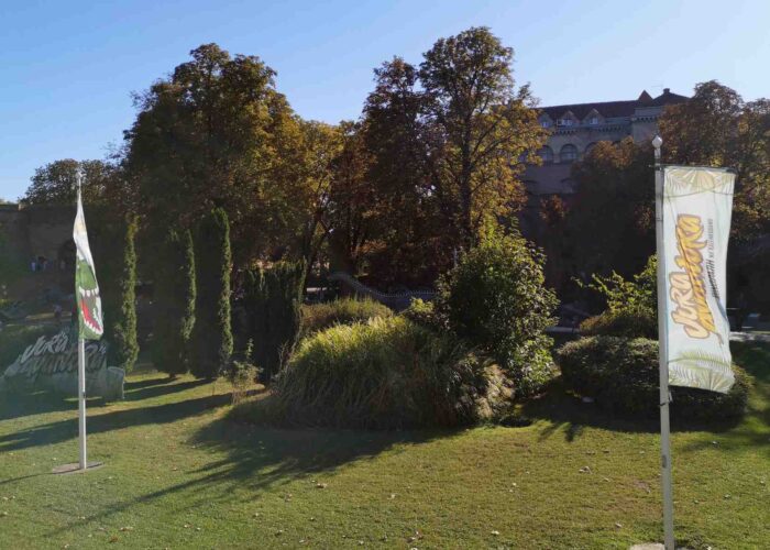 Panoramski pogled na Dino park na Kalemegdanu sa nekoliko figura dinosaurusa i stazama, sunčan dan.