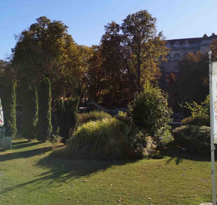 Panoramski pogled na Dino park na Kalemegdanu sa nekoliko figura dinosaurusa i stazama, sunčan dan.