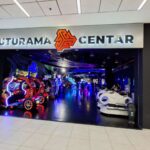 Svetleći, atraktivan ulaz u Futurama zabavni centar, sa logom i natpisom. Prikazuje atmosferu koja poziva na ulazak.