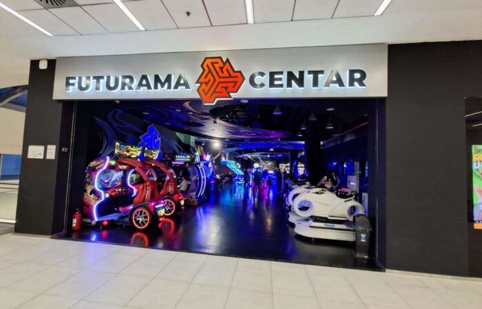 Svetleći, atraktivan ulaz u Futurama zabavni centar, sa logom i natpisom. Prikazuje atmosferu koja poziva na ulazak.
