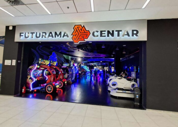 Svetleći, atraktivan ulaz u Futurama zabavni centar, sa logom i natpisom. Prikazuje atmosferu koja poziva na ulazak.