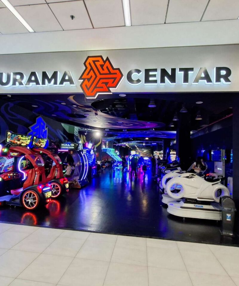 Svetleći, atraktivan ulaz u Futurama zabavni centar, sa logom i natpisom. Prikazuje atmosferu koja poziva na ulazak.