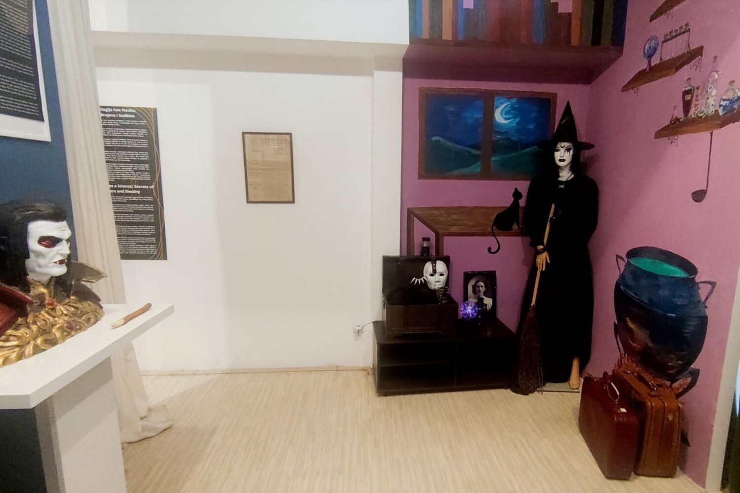 Prikaz unutrašnjosti muzejske sobe sa figurom veštice i rekvizitima, tematska postavka.