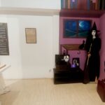 Prikaz unutrašnjosti muzejske sobe sa figurom veštice i rekvizitima, tematska postavka.