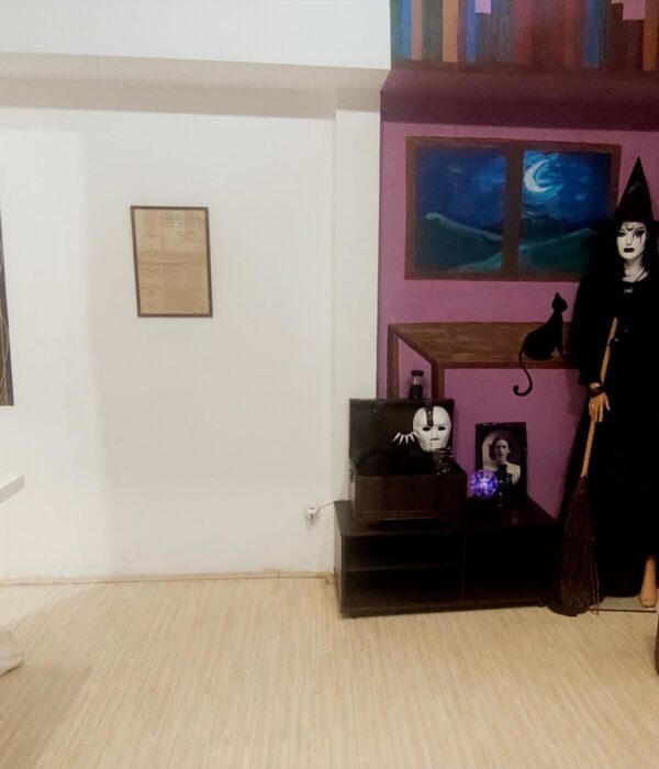 Prikaz unutrašnjosti muzejske sobe sa figurom veštice i rekvizitima, tematska postavka.
