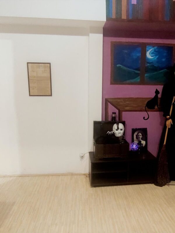 Prikaz unutrašnjosti muzejske sobe sa figurom veštice i rekvizitima, tematska postavka.