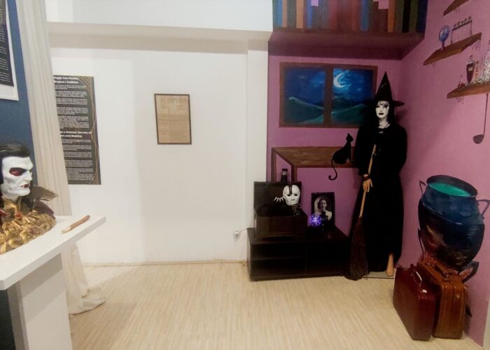 Prikaz unutrašnjosti muzejske sobe sa figurom veštice i rekvizitima, tematska postavka.
