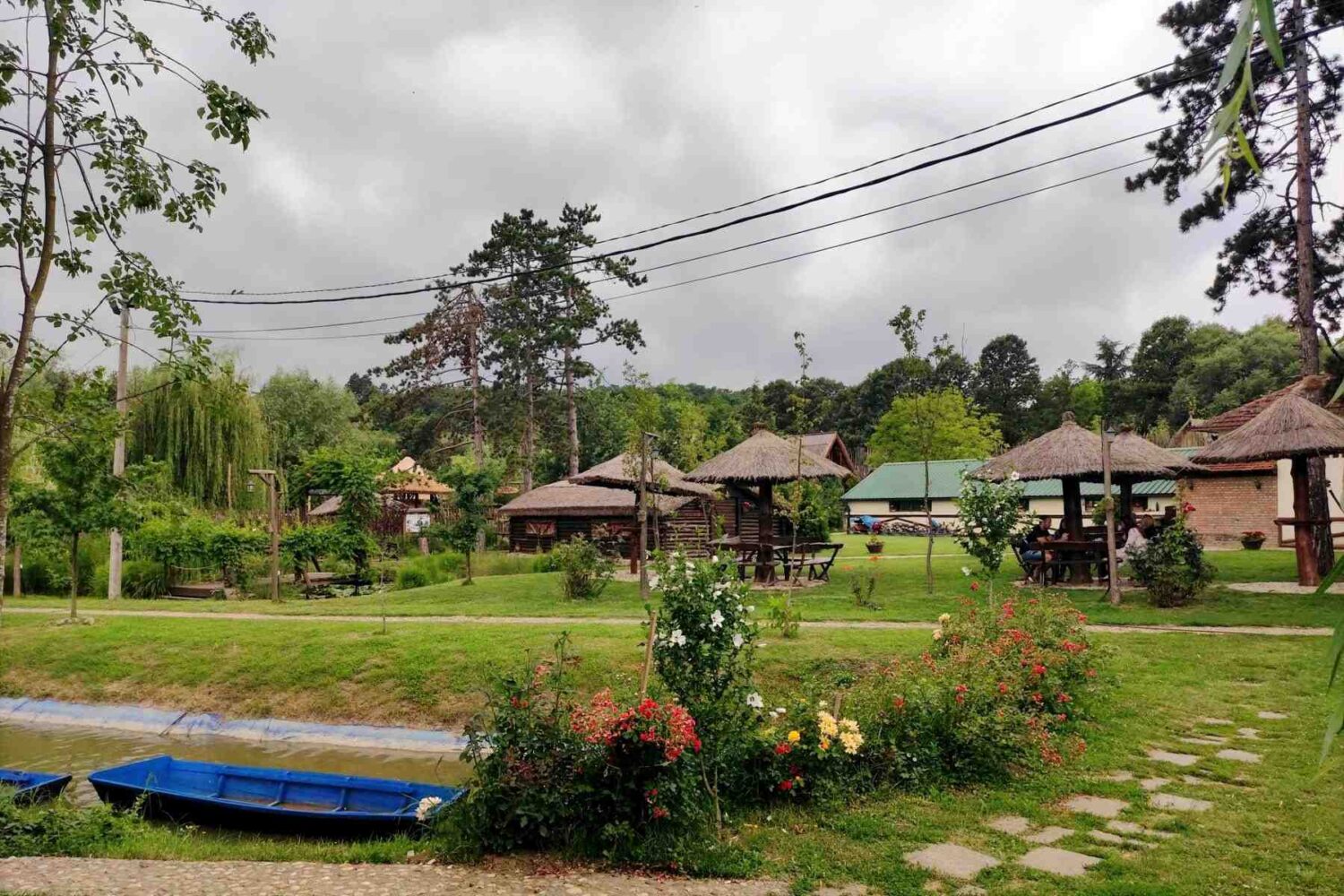 Čamci na jezercu okruženom zelenilom i klupama u Malom Dunavu u Beogradu