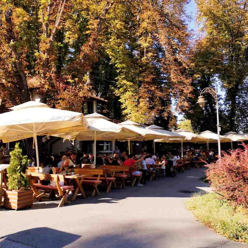 Restoran Kahvana Mali Kalemegdan sa baštom u Kalemegdanskom parku i gostima koji uživaju u hrani i piću