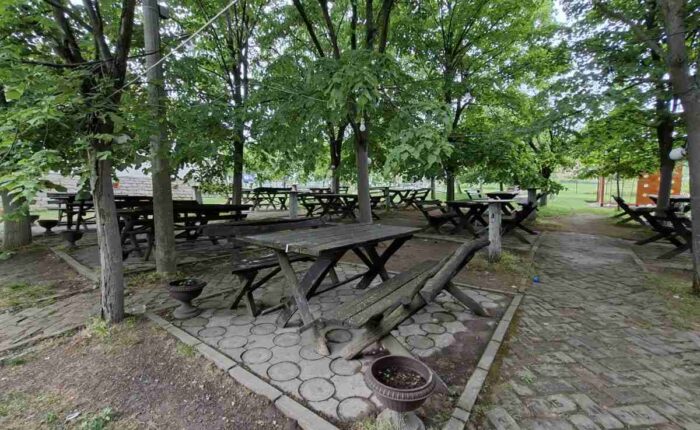 Kafana Kod Tome i Nade na Kosmaju sa drvenim stolovima u hladu drveća