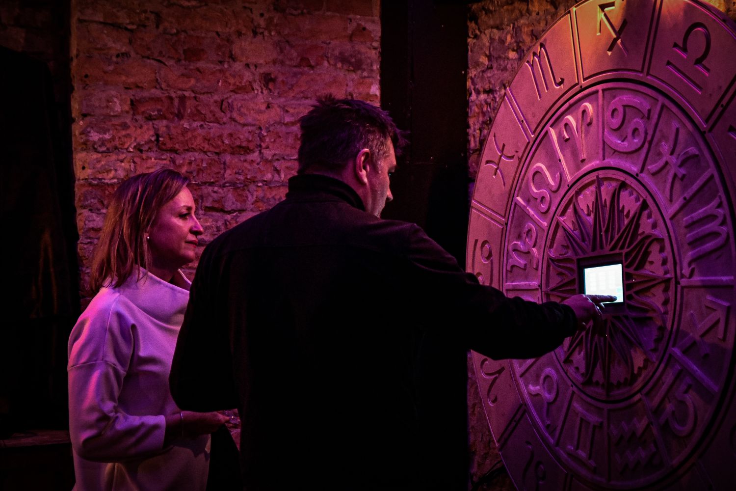 Interactive Exhibit at the Paranormal Museum Visitors exploring an interactive exhibit with mysterious symbols at the Paranormal Museum