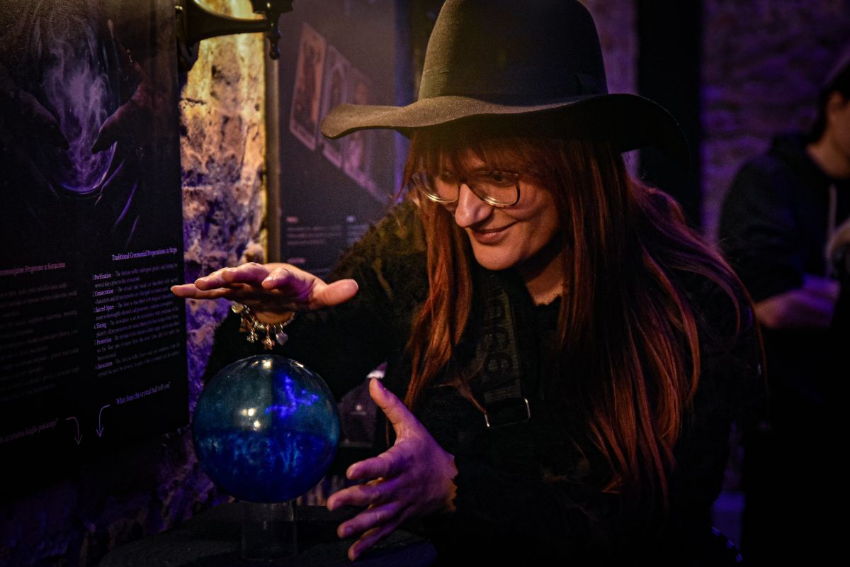 Crystal Ball and Fortune Telling Visitor exploring a crystal ball exhibit at the Paranormal Museum