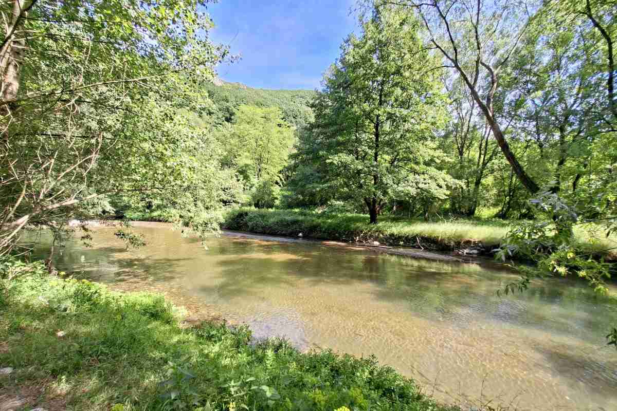 Mirni deo toka reke Gradac Širi i mirniji deo toka reke Gradac sa brdom u pozadini