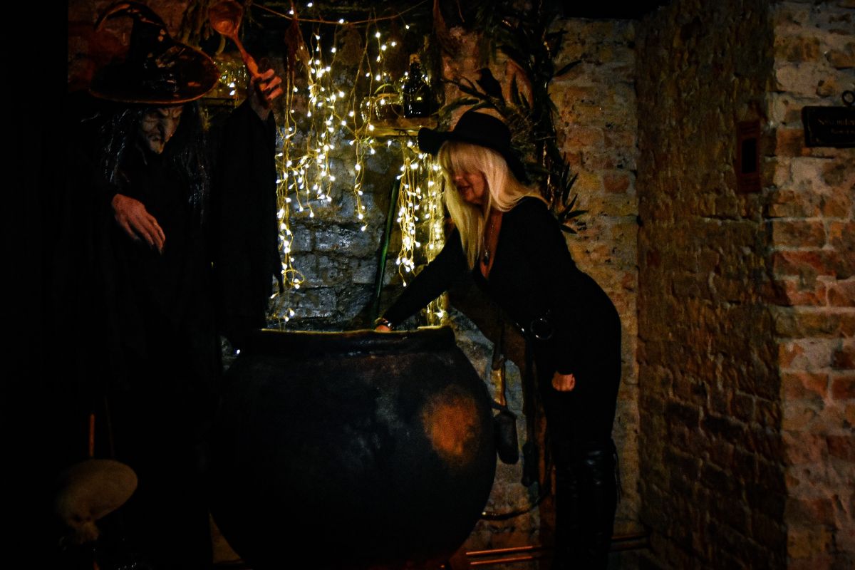 Witch’s Cauldron at the Paranormal Museum Witch figure beside a cauldron in a themed exhibit at the Paranormal Museum
