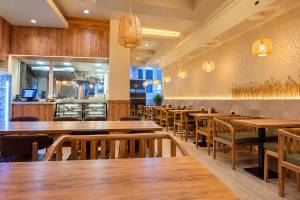 Enterijer restorana Silk Noodles sa drvenim stolovima, udobnim sedištima i dekorativnim svetiljkama